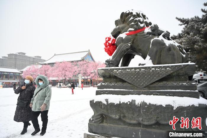 2月13日，民眾在呼和浩特市大召?gòu)V場(chǎng)雪中漫步?！⑽娜A 攝