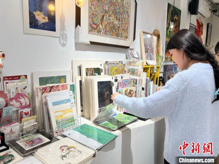 圖為藝術品商店內，顧客挑選插畫作品?！＄婌?攝