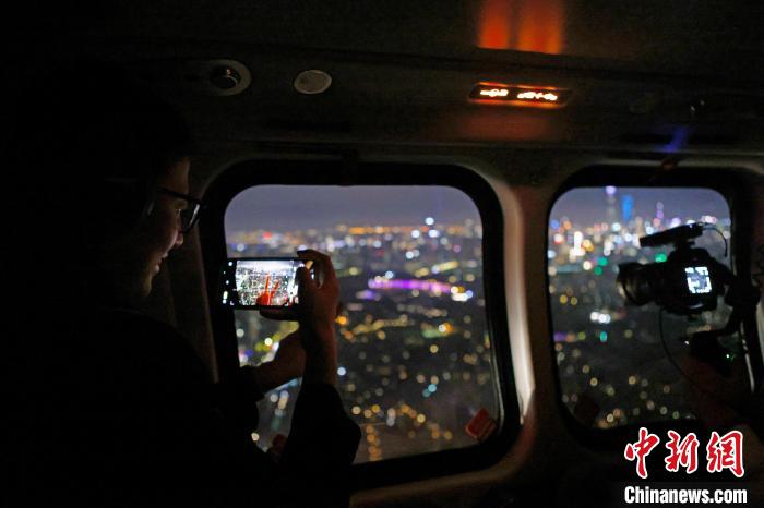 6月3日晚，游客乘坐上海新空直升機有限公司直升機開啟鳥瞰黃浦江空中圓夢之旅，并用手機拍攝城市夜景?！∫罅⑶?攝