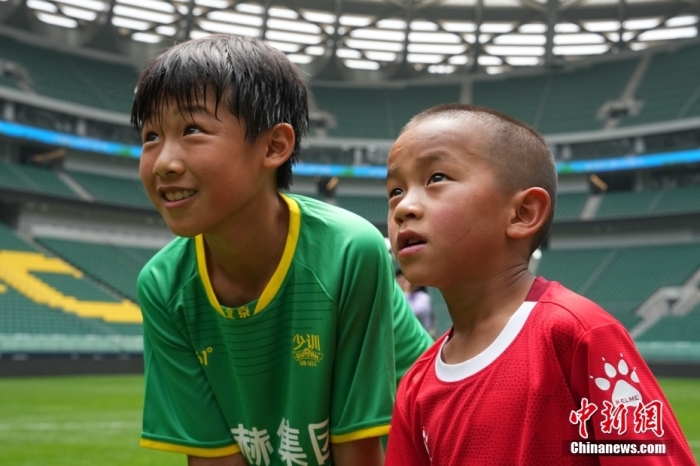 圖為北京國(guó)安小球員陳小北和7歲的俄金仁增在一起觀看場(chǎng)內(nèi)播放的紀(jì)錄片。<a target='_blank' href='/' _fcksavedurl='/'><p  align=