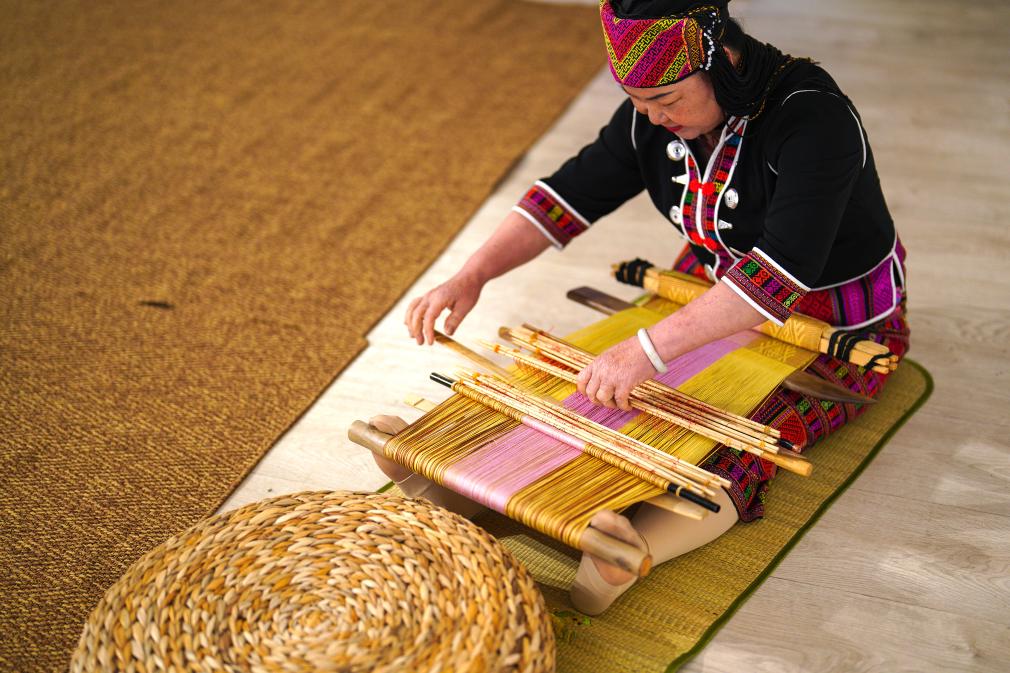 4月17日，黎族傳統(tǒng)紡染織繡技藝國家級代表性傳承人劉香蘭在2023年意大利米蘭設計周上展示黎錦織造技藝。新華社發(fā)