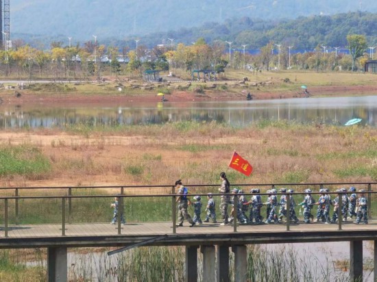 　　10月24日，秋游的幼兒園小朋友在老師帶領(lǐng)下走在清水塘公園里的木橋上。本報(bào)記者 常雯宜攝