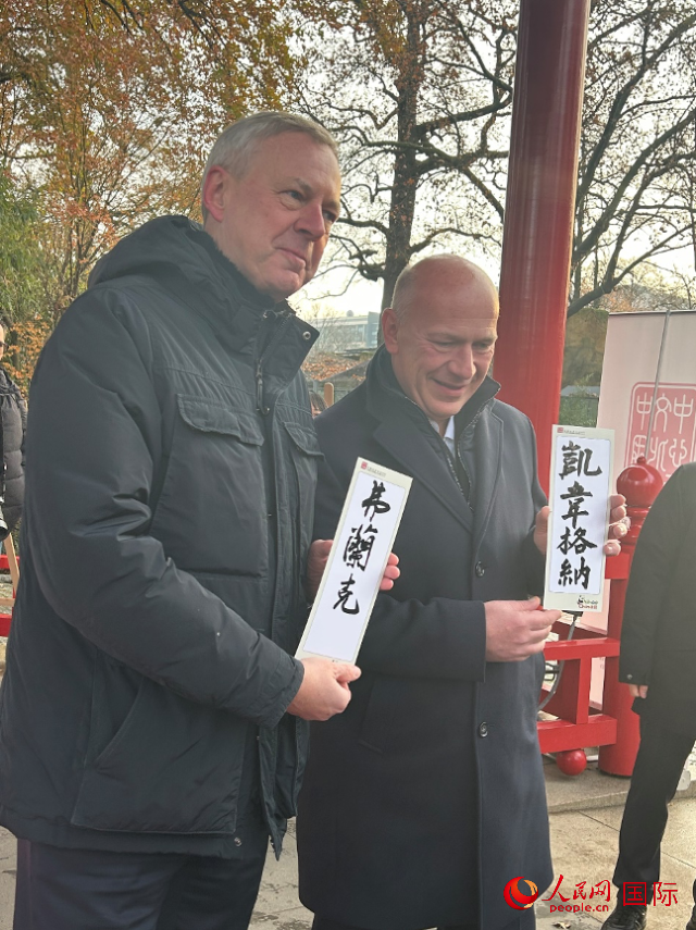 柏林市長(zhǎng)韋格納（右）、動(dòng)物園監(jiān)事會(huì)主席布魯克曼（左）手持中國(guó)文化中心工作人員現(xiàn)場(chǎng)手書(shū)的中文名字。人民網(wǎng)記者 徐馨攝