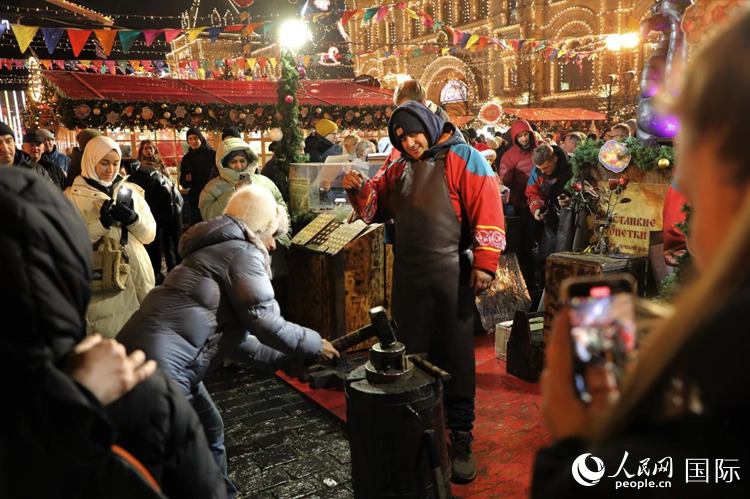 游客在新年集市上體驗(yàn)制作紀(jì)念幣。人民網(wǎng)記者 隋鑫攝