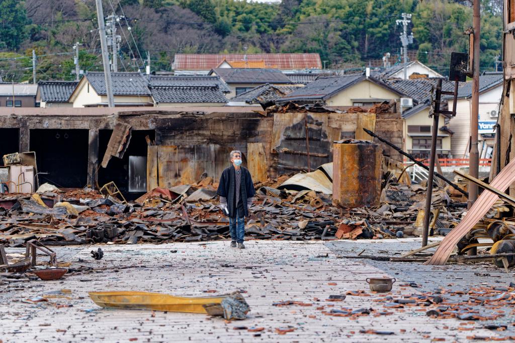 1月4日，一名市民查看日本石川縣輪島市“輪島早市”廢墟。新華社記者張笑宇攝