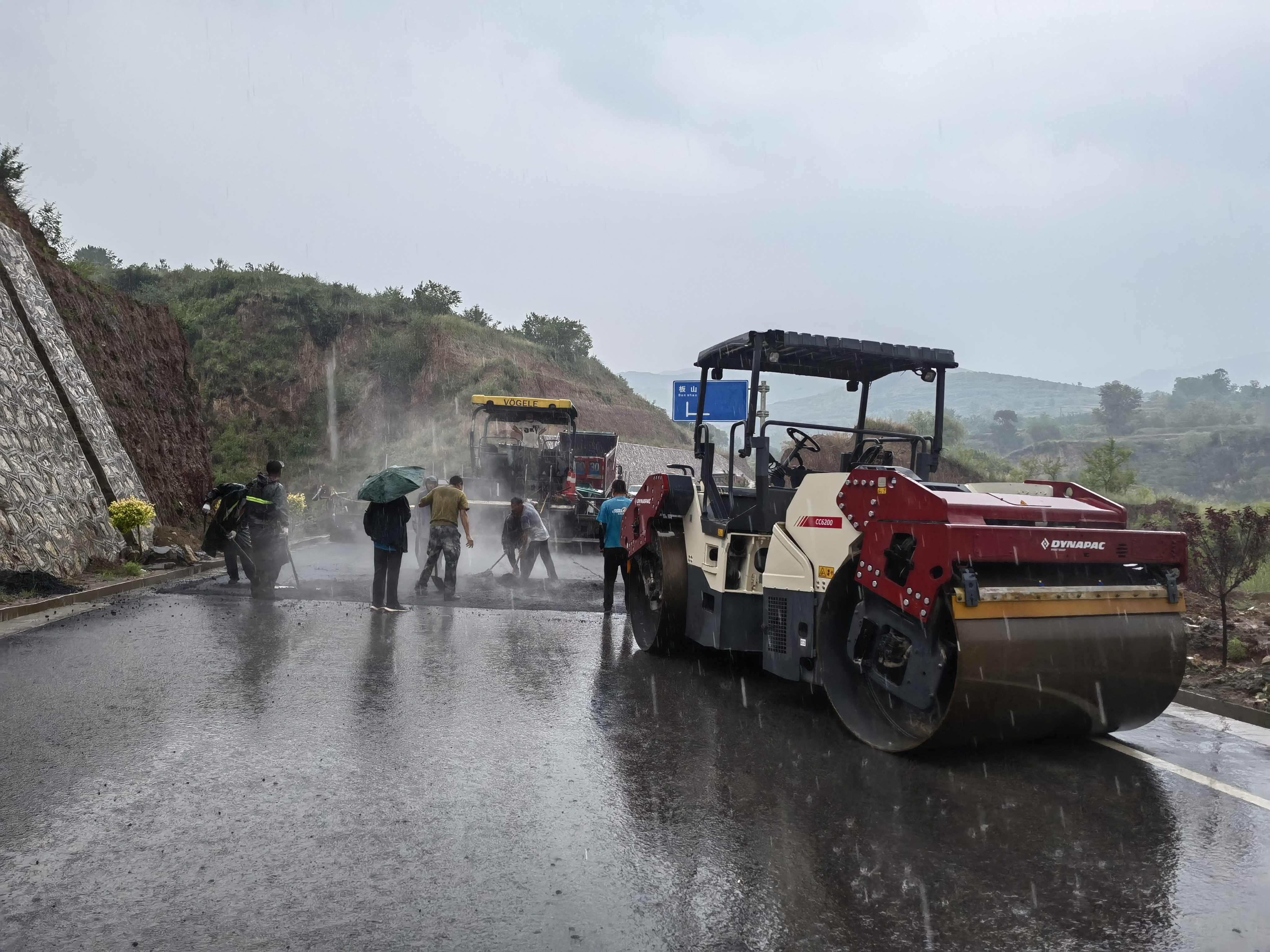 路橋工人在大雨中搶修道路。李華英 攝