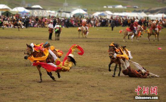 8月4日，四川理塘“八一”賽馬場(chǎng)上演一場(chǎng)精彩的馬術(shù)競(jìng)技比賽，引來(lái)上萬(wàn)民眾和游客觀賽。圖為牧民騎手進(jìn)行五彩凌空競(jìng)技。 中新社記者 劉忠俊 攝