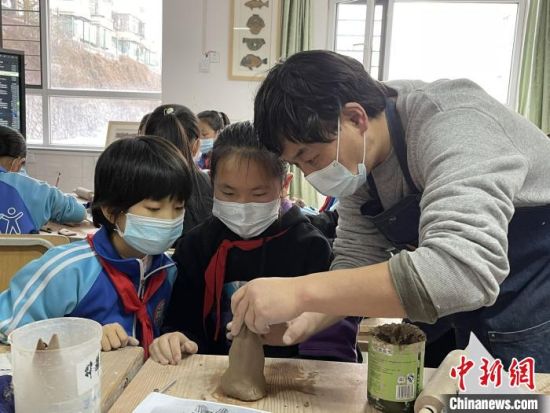 圖為西寧市勞動路小學(xué)教師賈煜與學(xué)生一起制作陶藝?！≈苋鸪阶?攝