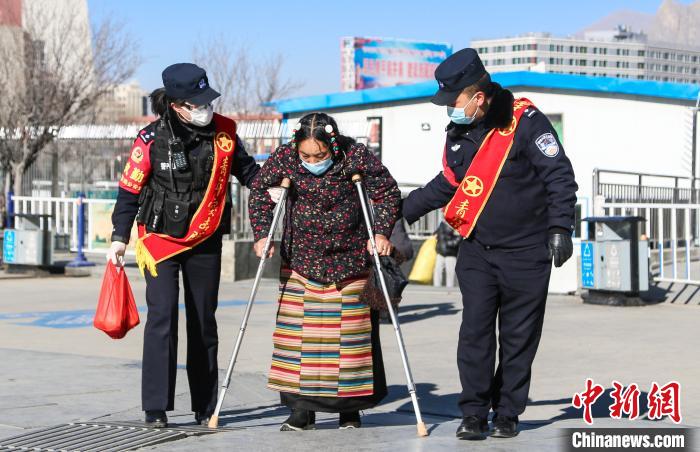 圖為拉薩鐵路公安民警幫助老人進(jìn)站乘車。　胡安鵬 攝