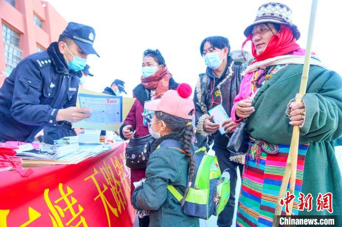 圖為拉薩鐵路公安民警向旅客發(fā)放乘車安全宣傳資料?！↑S飛 攝