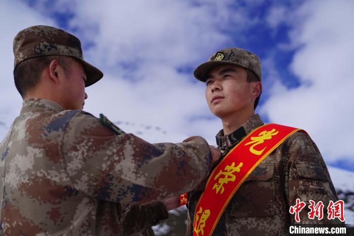 排長王朝偉(圖左)給退伍老兵佩戴大紅花?！∥鞑厣侥宪姺謪^(qū)某團(tuán)供圖