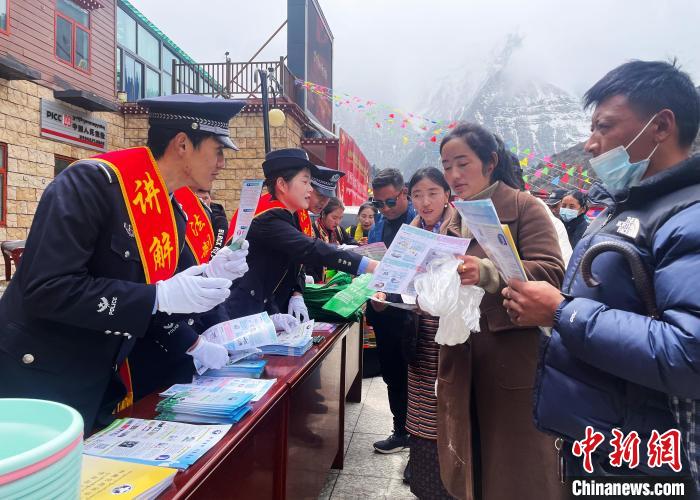 圖為山南玉麥邊境派出所民警為轄區(qū)群眾發(fā)放法律知識宣傳單?！＄婗?　攝