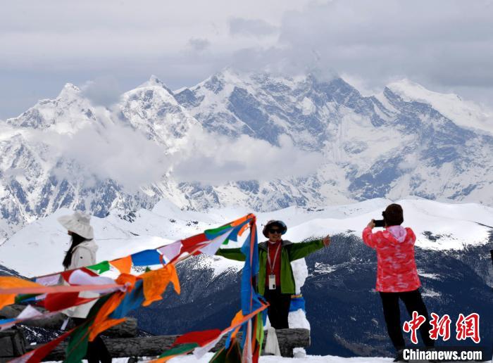 圖為5月14日，西藏林芝色季拉山觀景臺(tái)，游客與南迦巴瓦峰合影?！±盍?攝