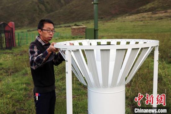 圖為班瑪縣氣象局工作人員在維護藏雪茶基地氣候站。青海省氣象局供圖