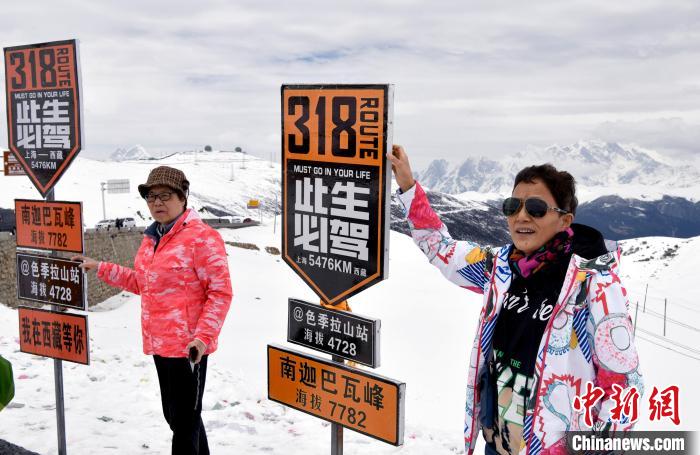 圖為5月14日，西藏林芝色季拉山觀景臺，游客與南迦巴瓦峰合影?！±盍?攝