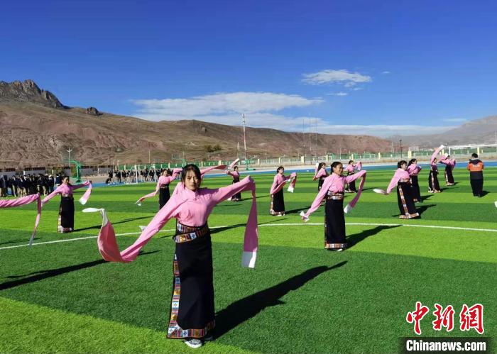 圖為青海師范大學(xué)附屬玉樹實驗學(xué)校學(xué)生在綠茵場跳起囊謙古舞—卓根瑪。　白劼 攝