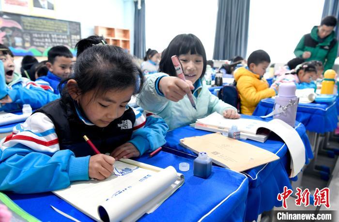 3月14日，西藏拉薩市第一小學(xué)一年級六班學(xué)生白瑪朗珍(圖左)在藏語文課上書寫藏文。　李林 攝