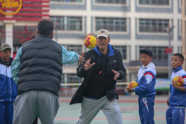 在高原上教孩子們打手球，“慢慢兒來，甭著急！”