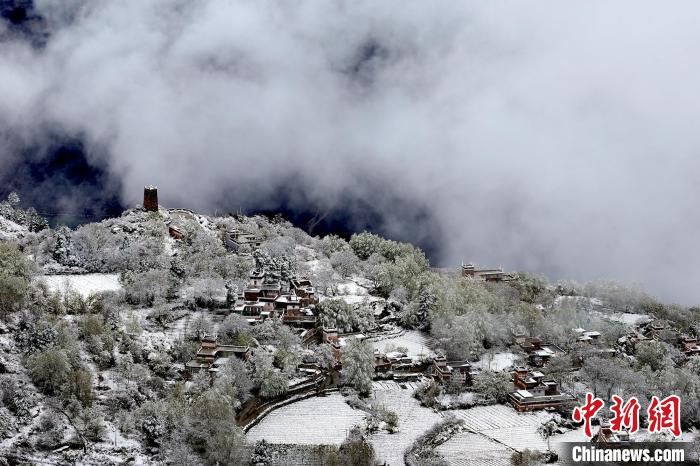 雪后的藏寨和碉樓構(gòu)成美麗的雪景?！〗党鯘衫?攝