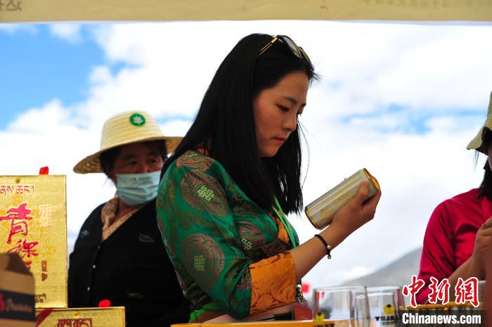 圖為拉薩市民在特色農(nóng)畜產(chǎn)品展示展銷會上選購商品?！垈?攝