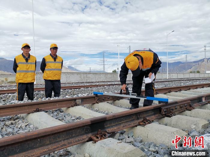 圖為參賽選手在比賽項(xiàng)目中用軌距尺測(cè)量鋼軌距離。　趙延 攝