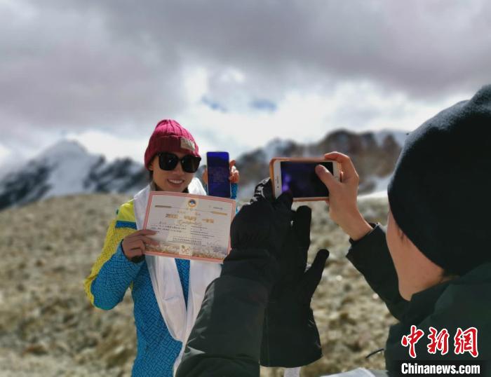 圖為5日，登頂洛堆峰的登山者獲得西藏自治區(qū)登山協(xié)會頒發(fā)的登頂證明。　張偉 攝