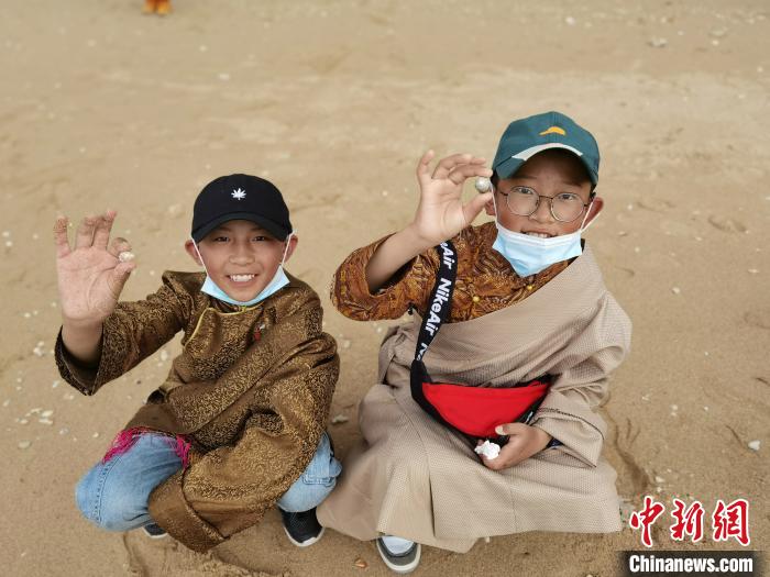 圖為西藏青少年在海邊拾貝殼。西藏航空 供圖