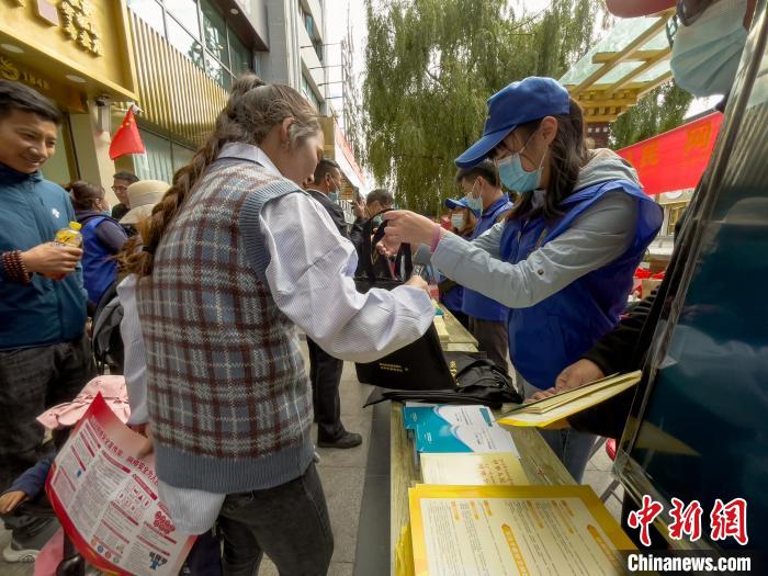 圖為志愿者為市民發(fā)放網(wǎng)絡安全宣傳手冊?！≈x牧 攝