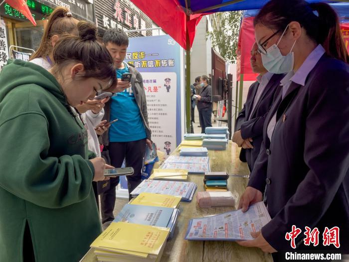 圖為工作人員正在向路過市民介紹國家反詐中心軟件的功能。　謝牧 攝