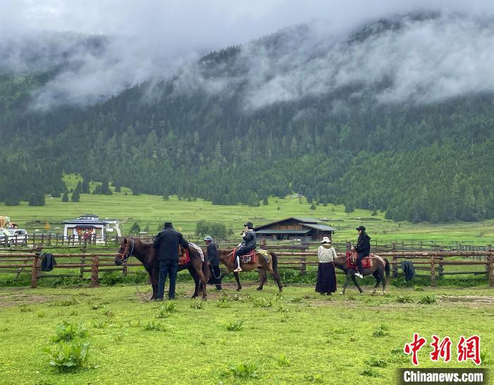 6月10日，游客在魯朗小鎮(zhèn)高山牧場(chǎng)景區(qū)體驗(yàn)騎馬?！∪轿木?攝