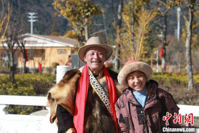 圖為林芝市巴宜區(qū)布久鄉(xiāng)仲果村村民桑杰與孫子一起參加藏歷新年活動(dòng)?！埩?攝