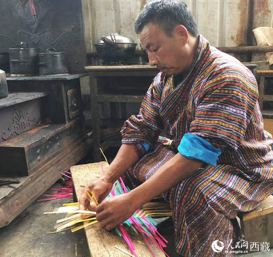 門巴族漢子愛明正在編織藤竹品。